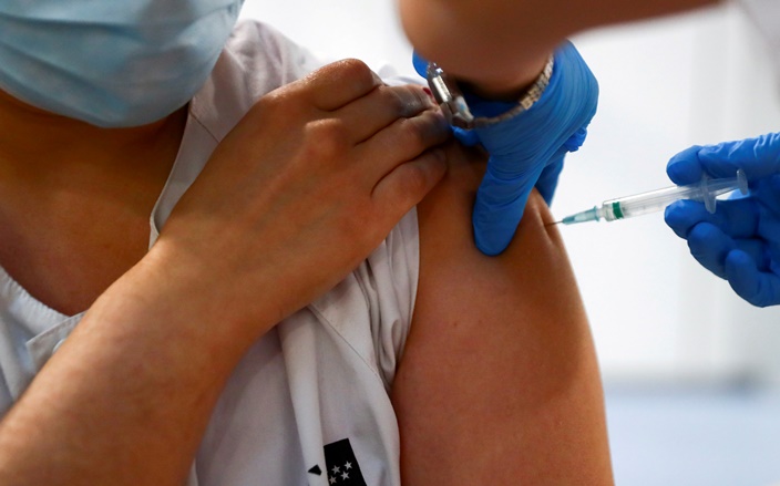 A health worker receives a dose of the Pfizer-BioNTech COVID-19 vaccine in Madrid, Spain, February 4, 2021.