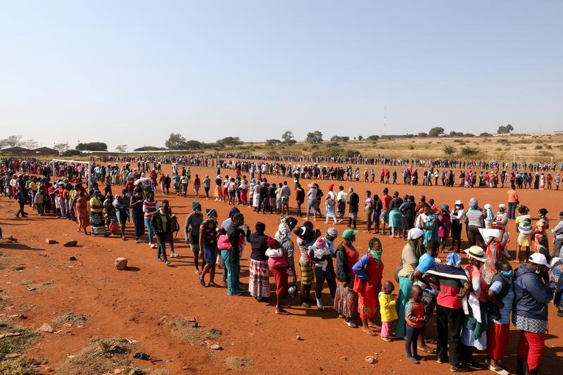 People stand in a queue to receive food aid amid the spread of the coronavirus disease, at the Itireleng informal settlement, near Laudium in Pretoria, South Africa, May 20, 2020