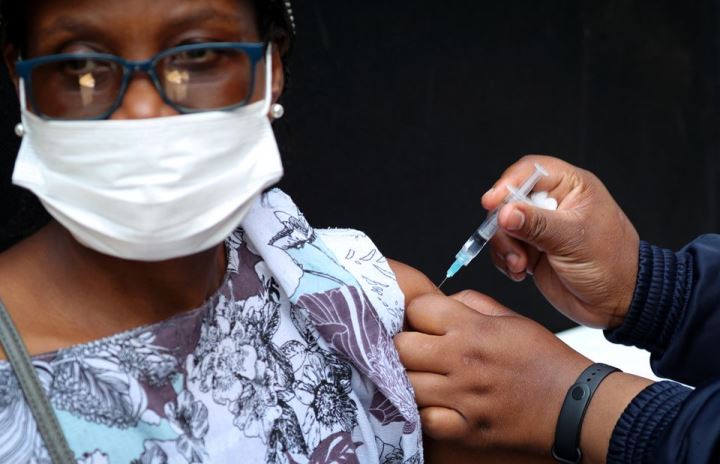 A healthcare worker administers the Johnson and Johnson coronavirus disease vaccination to a woman in Houghton, Johannesburg, South Africa, August 20, 2021.