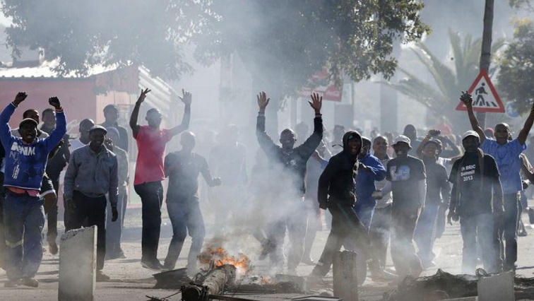 Demonstrators cheer as they tear down a street lamp during a protest against what they said was the government's failure to provide adequate housing facilities and other basic services in Cape Town's Langa township, July 9, 2014.
