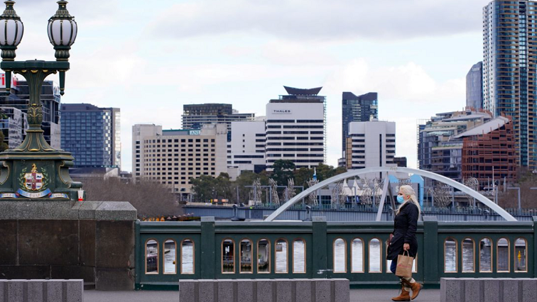 A lone woman, wearing a protective face mask, walks across a city centre bridge as the state of Victoria looks to curb the spread of a coronavirus disease (COVID-19) outbreak in Melbourne, Australia, July 16, 2021.
