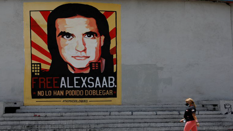 A woman walks by a mural in support of the liberation of Colombian businessman and envoy Alex Saab, who is detained in Cape Verde on charges of laundering money for the government of Venezuelan President Nicolas Maduro, in Caracas, Venezuela September 9, 2021.
