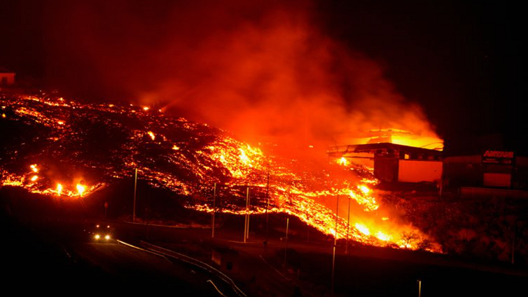 Lava burns buildings following the eruption of the Cumbre Vieja volcano, in Tacande, Spain, October 9, 2021.