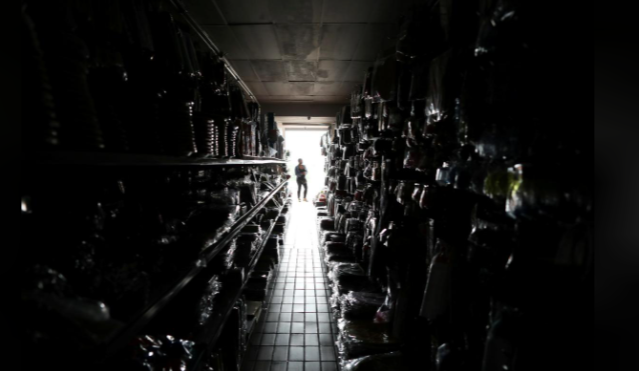 A shop assistant stands at the door during a power blackout in South Africa