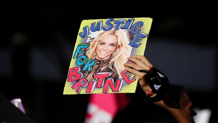 A supporter of singer Britney Spears holds up a picture of the pop star with the words "Justice for Britney" during celebrations for the termination of her conservatorship, outside the Stanley Mosk Courthouse in Los Angeles, California, U.S. November 12, 2021.