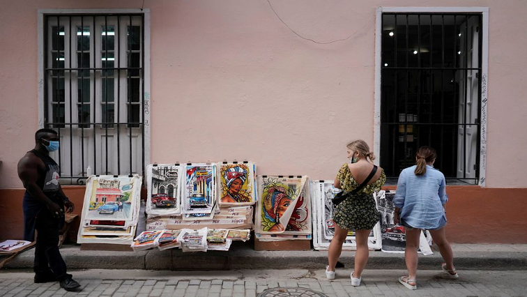 Tourists from Russia look at paintings for sale in downtown Havana, Cuba, November 24, 2021.