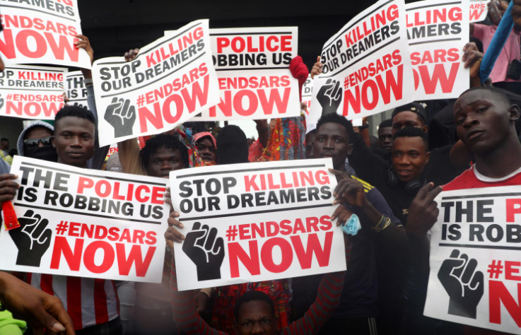Demonstrators carry banners during a protest over alleged police brutality, in Lagos, Nigeria October 14, 2020.