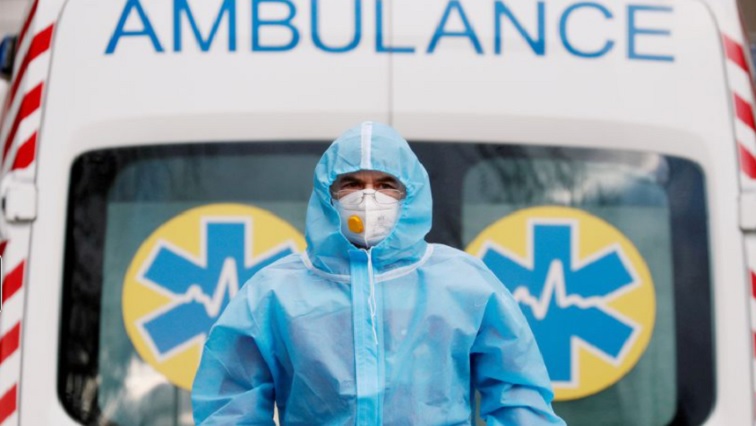 A medical worker wearing protective gear stands next to an ambulance outside a hospital for patients infected with COVID-19 in Kyiv, Ukraine, November 24, 2020.