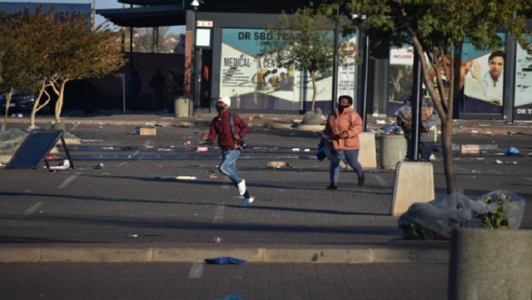 Looters flee from the Sam Ntuli Mall in Katlehong.