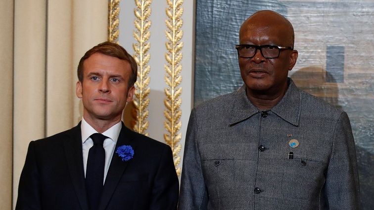 French President Emmanuel Macron poses with Burkina Faso's President Roch Marc Christian Kabore as they attend a dinner on the first day of the Paris Peace Forum, at the Elysee Palace in Paris, France