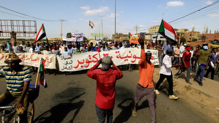Protesters carry a banner and national flags as they march against the Sudanese military's recent seizure of power and ousting of the civilian government, in the streets of the capital Khartoum, Sudan October 30, 2021.