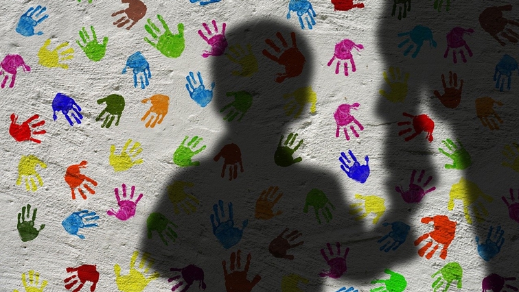 File image reflecting a  silhouette of a child holding an adult's hand.