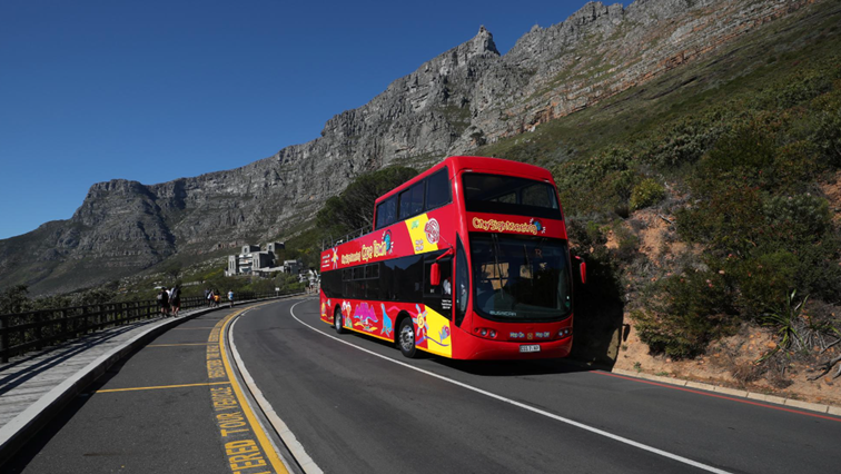 An almost empty tour bus drives below the city's iconic landmark Table Mountain in Cape Town, South Africa, during the coronavirus disease (COVID-19) outbreak, August 22, 2020. Picture taken August 22, 2020. REUTERS/Mike Hutchings