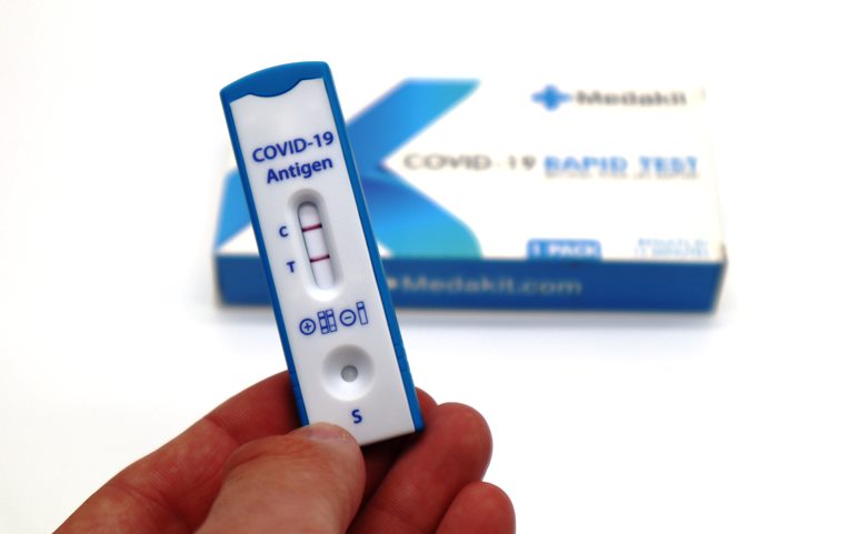A person holds an antigen COVID-19 test