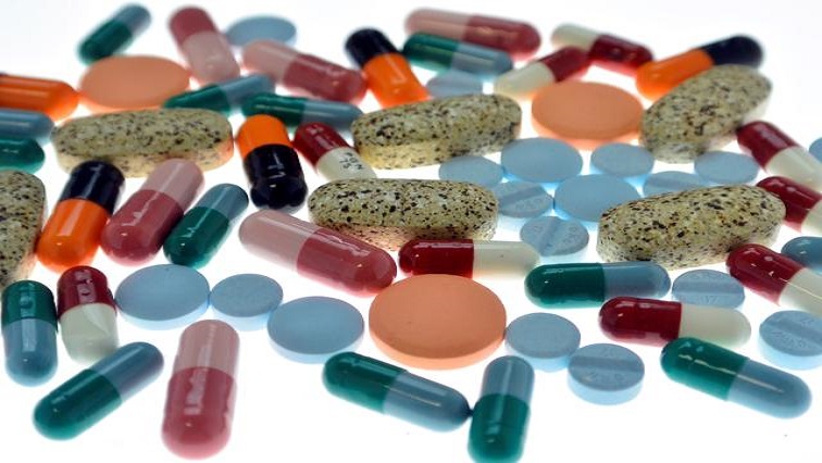 Pharmaceutical tablets and capsules are arranged on a table in a photo illustration.