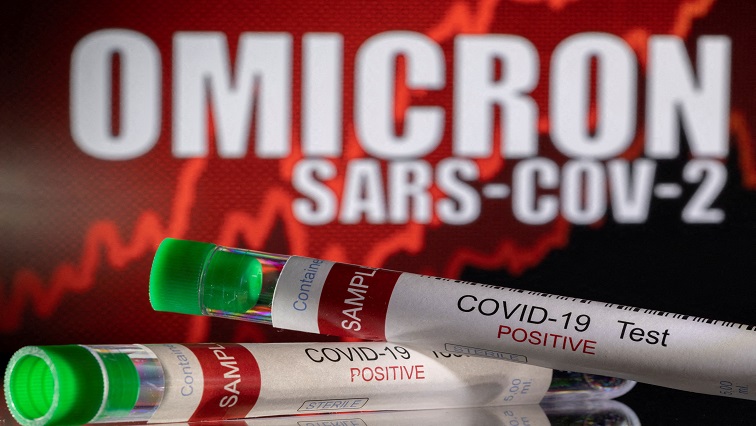 Test tubes labelled "COVID-19 Test Positive" are seen in front of displayed words "OMICRON SARS-COV-2"