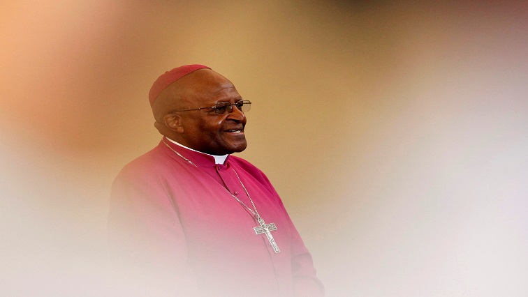 FILE PHOTO: Archbishop Desmond Tutu is seen through crowds during a visit to a youth centre in Masiphelele township near Cape Town, South Africa,  July 8, 2011. REUTERS/Mike Hutchings/File Photo