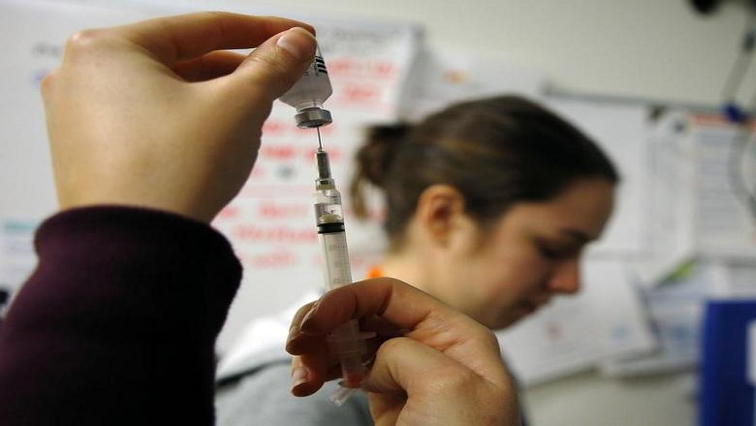 Nurses prepare influenza vaccine injections.