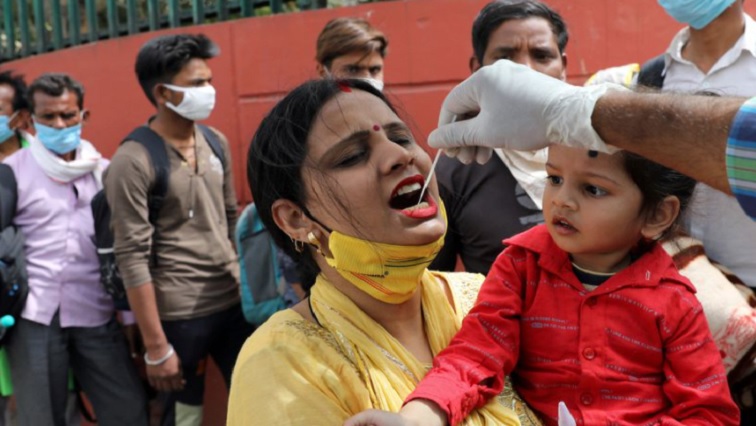 A healthcare worker collects a swab sample from a woman amidst the spread of coronavirus disease (COVID-19), at a bus station, in New Delhi, India March 16, 2021.