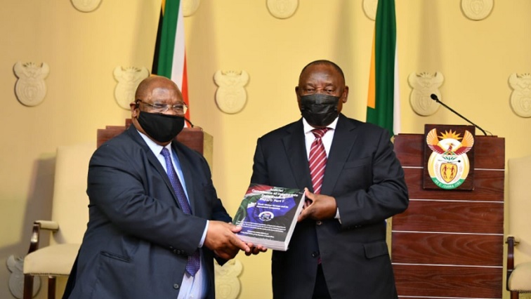 Deputy Chief Justice Raymond Zondo (L) hands over the State Capture report to President Cyril Ramaphosa (R).