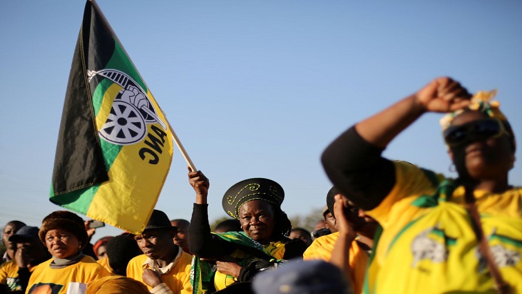 Supporter of the African National Congress holds the party's flag at an event.