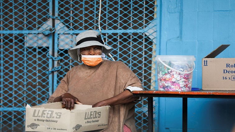 A woman wearing a protective face mask against the coronavirus disease (COVID-19) sits next to her stall, as the new Omicron coronavirus variant spreads, at Tsomo, a town in the Eastern Cape province of South Africa, December 2, 2021.