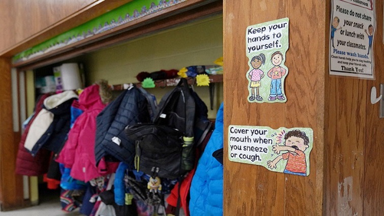 Signs hang to remind children of precautions to prevent the spread of COVID-19 in the classroom at South Boston Catholic Academy in Boston, Massachusetts, US, January 28, 2021.