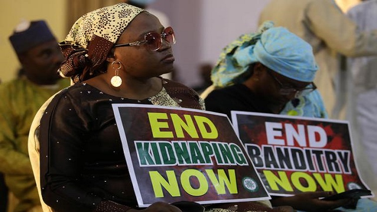 [File photo] A demonstrator holds a sign during a protest to urge authorities to rescue hundreds of abducted schoolboys in northwest state of Katsina, Nigeria.