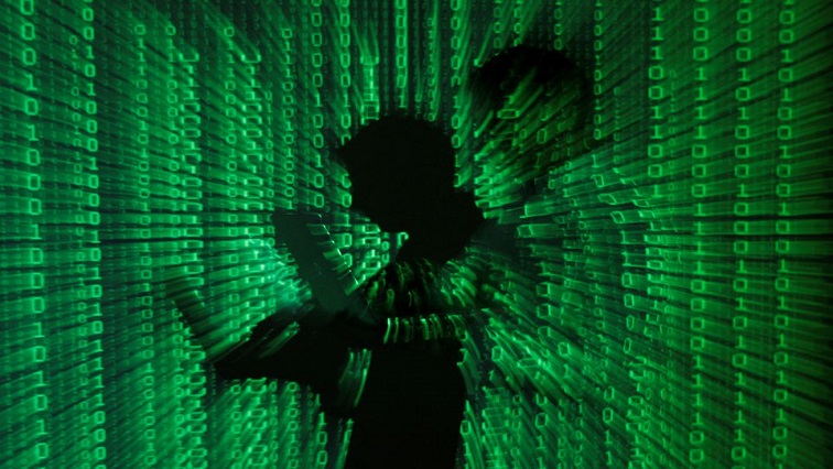 An illustration picture shows a projection of binary code on a man holding a laptop computer.