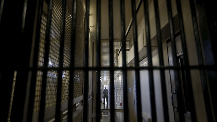 A guard is seen from a distance in a prison.