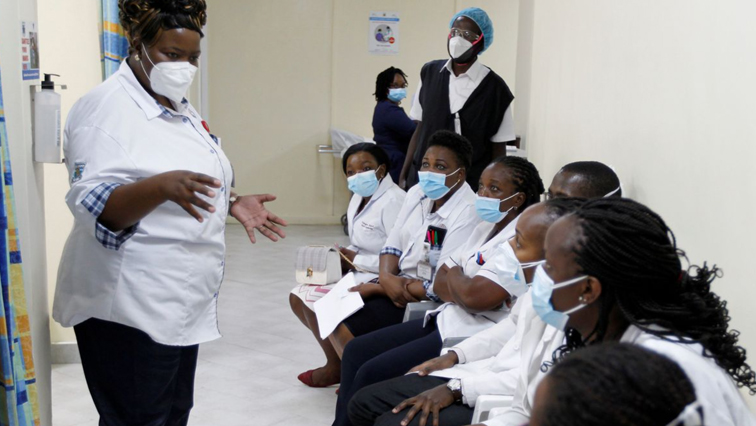 A health worker talks to her colleagues as they prepare to receive the AstraZeneca/Oxford vaccine under the COVAX scheme against coronavirus disease (COVID-19) at the Kenyatta National Hospital in Nairobi.
