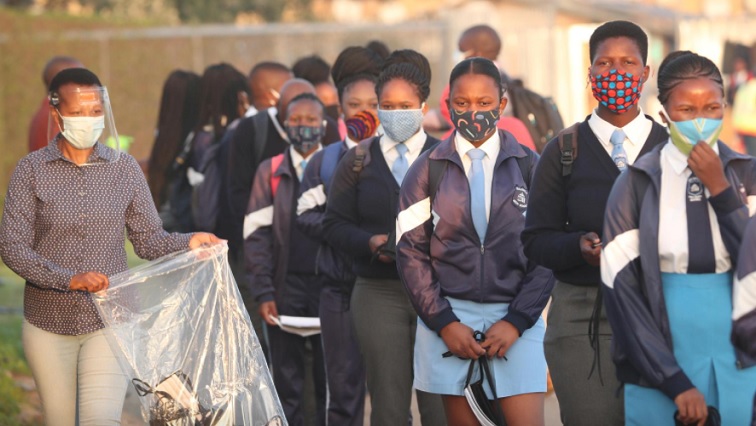 (File Image) A teacher distributes masks to students as schools begin to reopen after the coronavirus disease (COVID-19) lockdown in Langa township in Cape Town, South Africa June 8, 2020