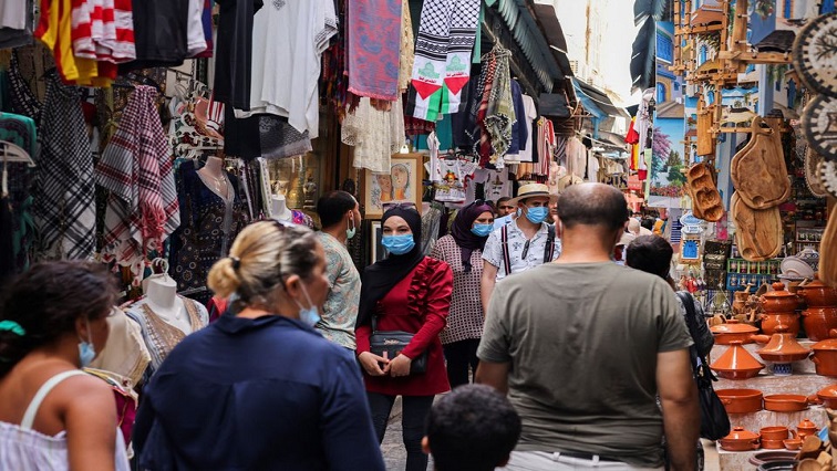 People wearing protective face masks walk past shops, amid the coronavirus disease (COVID-19) outbreak, in the Old City of Tunis, Tunisia, August 3, 2021.