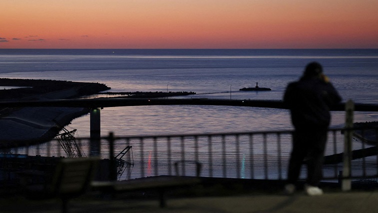 A local resident watches the coastal area from Hiyoriyama Park after a tsunami warning was issued for coastal towns in northeastern Japan after an underwater volcano eruption on the island of Tonga at the South Pacific, in Ishinimaki, Miyagi prefecture, Japan, in this photo taken by Kyodo January 16, 2022.
