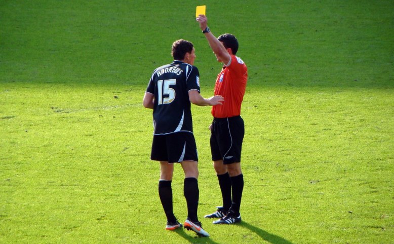 File Photo: Referee showing a soccer player the yellow card for a foul