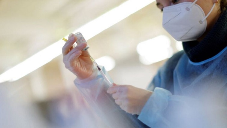 A nurse prepares a booster dose of COVID-19 vaccine