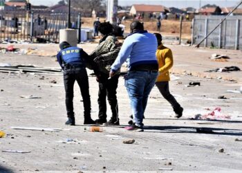 Police conducting a body search on one of the suspected July unrest looters