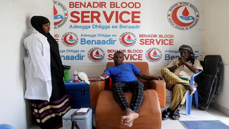 Mohamed Abdi Hussein donates blood next to Rage Moalin Ali, who waits to donate blood, and nurse Fatima Hassan, at the Benadir Blood Service, in Mogadishu, Somalia February 7, 2022.