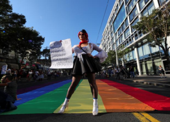 A participant attends an annual LGBT pride parade in Belgrade, Serbia, September 15, 2019. The banner reads "Transgender people deserve the right to work, home and health protection."