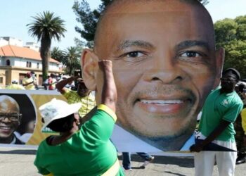 A supporter gestures in front of a picture of Ace Magashule ahead of his court appearance at the Bloemfontein High Court on November 13, 2020.