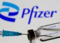 Syringe and vial are seen in front of displayed new Pfizer logo in this illustration taken, June 24, 2021.