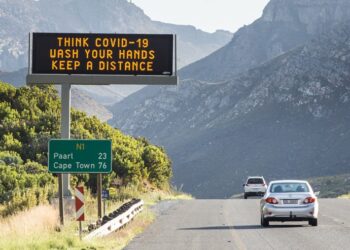 A vehicle passes a COVID-19 awareness sign in the Western Cape