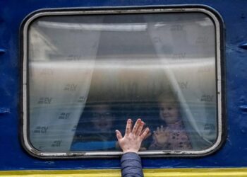 Children look out from an evacuation train from Kyiv to Lviv as they say goodbye to their father at Kyiv central train station in Kyiv, Ukraine, March 3.