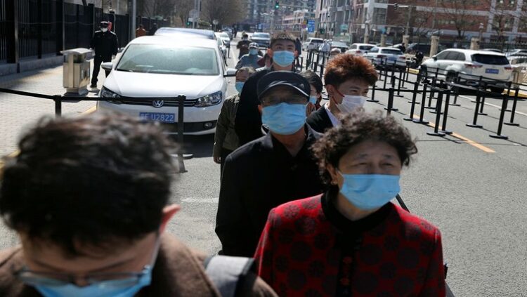 Residents wearing face masks line up at a makeshift nucleic acid testing site during a mass testing for the coronavirus disease (COVID-19), in Chaoyang district of Beijing, China March 14, 2022.