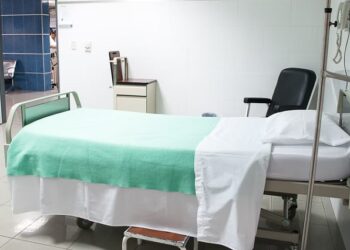 File Image: A hospital room with a patient bed and chair.