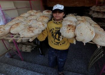 An Egyptian worker carries loaves of bread at a bakery in Cairo's southeastern Mokattam district, as the prices of basic goods in Egypt have risen since Russia's invasion of Ukraine, in Egypt, March 16, 2022.