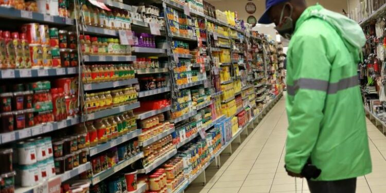 A shopper wearing a face mask looks at grocery items, at Mall of the South, in Johannesburg
