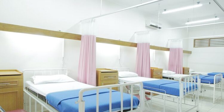 A hospital ward with empty beds.