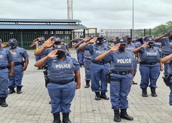 Members of the South African Police Service salute while on parade