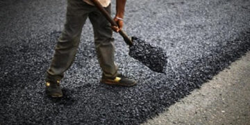 A person seen working on a tar road.